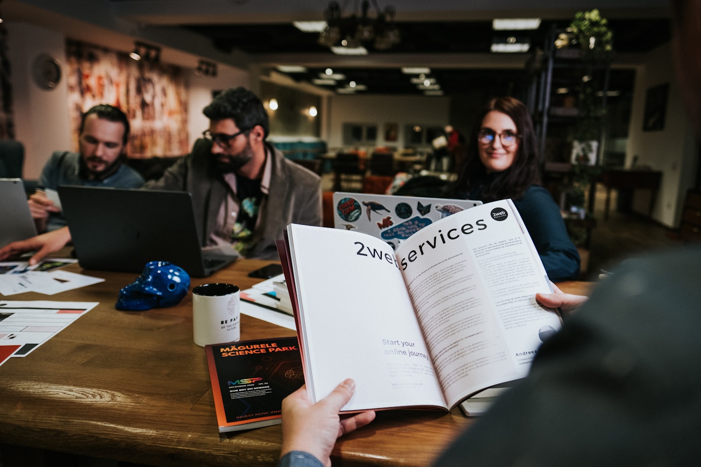 Professionals collaborating around a table with a brochure.